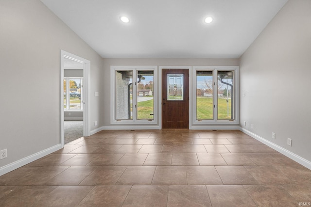 interior space with lofted ceiling and light tile patterned floors