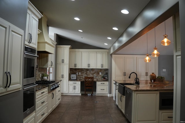 kitchen with pendant lighting, sink, appliances with stainless steel finishes, dark stone countertops, and backsplash