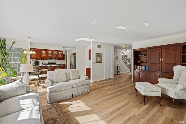 living room with an inviting chandelier and light wood-type flooring