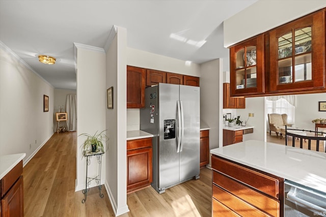 kitchen with ornamental molding, light hardwood / wood-style floors, and stainless steel fridge with ice dispenser