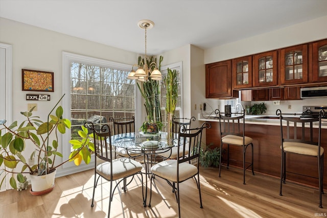 dining space featuring light wood-type flooring and a chandelier