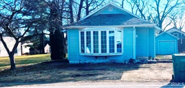 view of front of property with a garage and an outbuilding