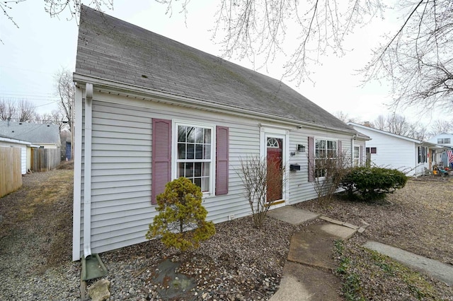 view of front of home featuring roof with shingles and fence