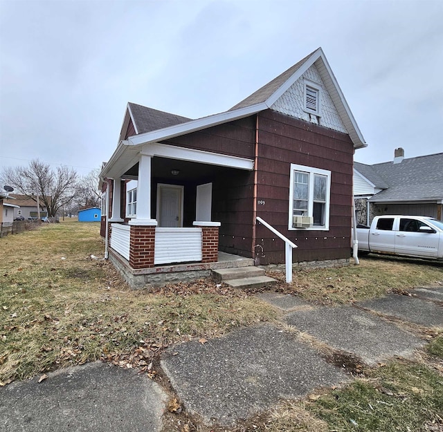 view of front of house with covered porch and a front lawn