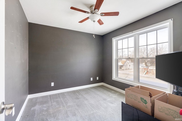 carpeted spare room featuring ceiling fan