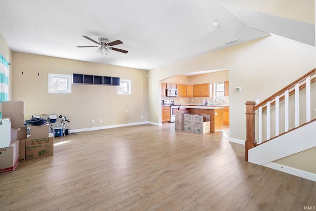 living room with ceiling fan, sink, and light hardwood / wood-style floors