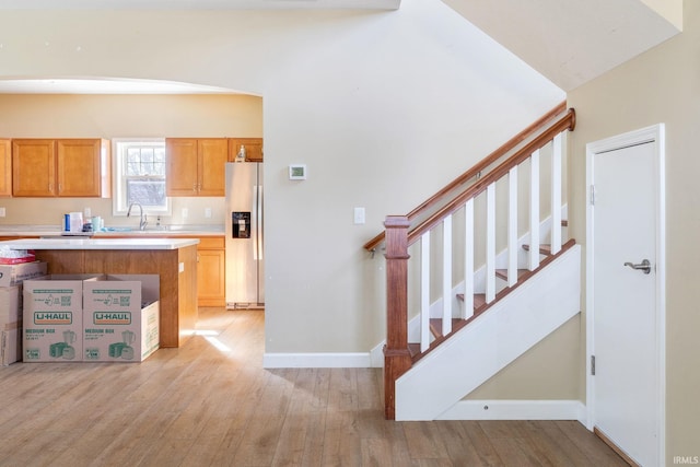 kitchen featuring sink, light wood-type flooring, and stainless steel refrigerator with ice dispenser