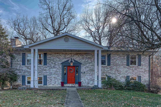 raised ranch featuring a front lawn