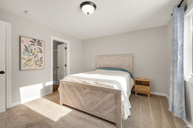 bedroom featuring light carpet and baseboards