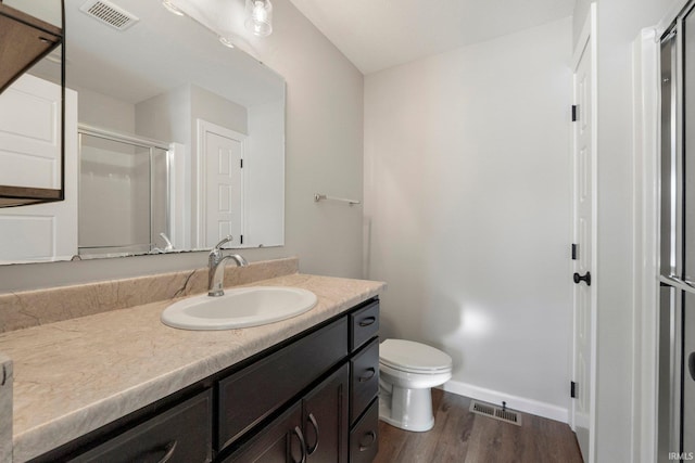 full bathroom featuring visible vents, toilet, a shower stall, vanity, and wood finished floors