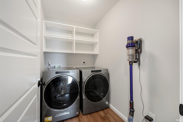 clothes washing area with laundry area, independent washer and dryer, baseboards, and wood finished floors