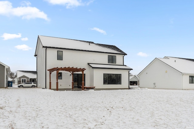 snow covered rear of property featuring a pergola