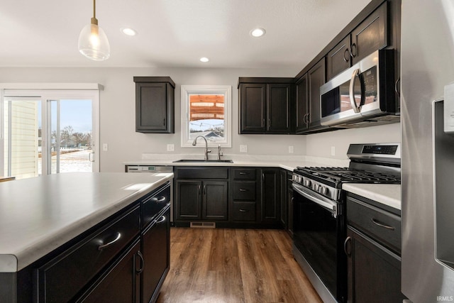 kitchen featuring appliances with stainless steel finishes, dark wood-style flooring, plenty of natural light, and a sink