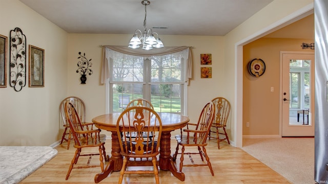 dining space with plenty of natural light, a chandelier, and light hardwood / wood-style floors