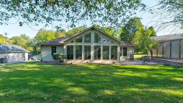 rear view of house with a yard, a sunroom, and a patio