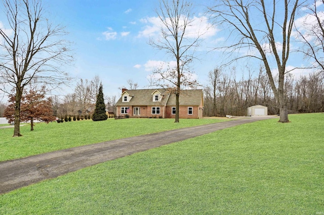 cape cod home with an outbuilding, a garage, and a front yard