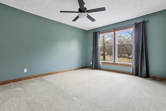 carpeted spare room with ceiling fan and a textured ceiling