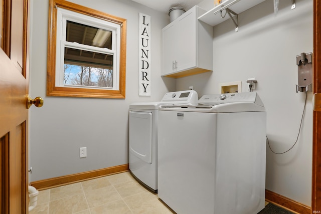 clothes washing area with washer and clothes dryer and cabinets