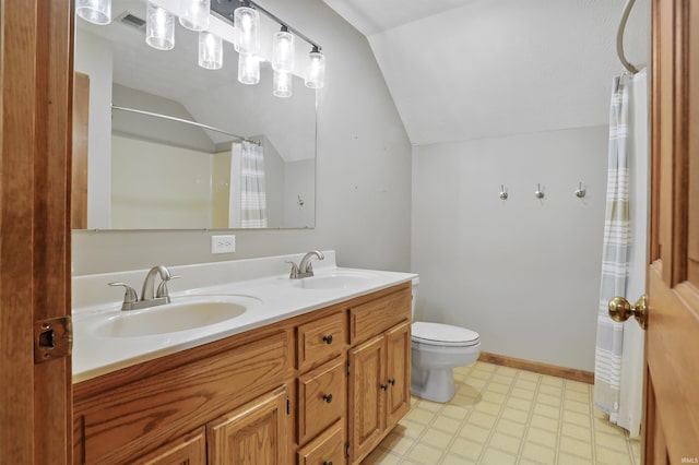 bathroom with vaulted ceiling, vanity, and toilet