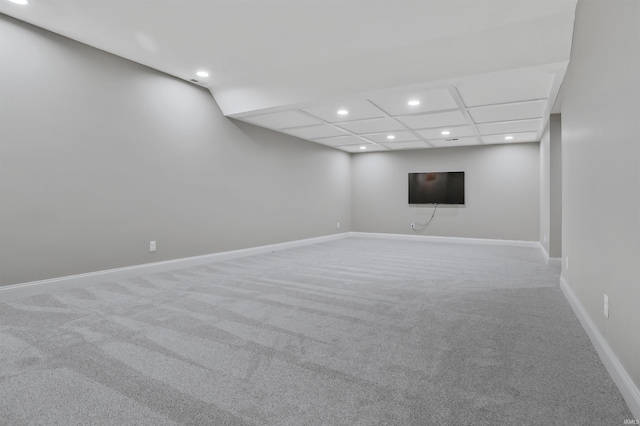 basement with carpet and a paneled ceiling