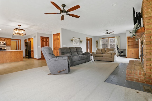 carpeted living room featuring ceiling fan and a brick fireplace