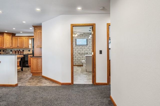 kitchen with tasteful backsplash, dark colored carpet, and black dishwasher