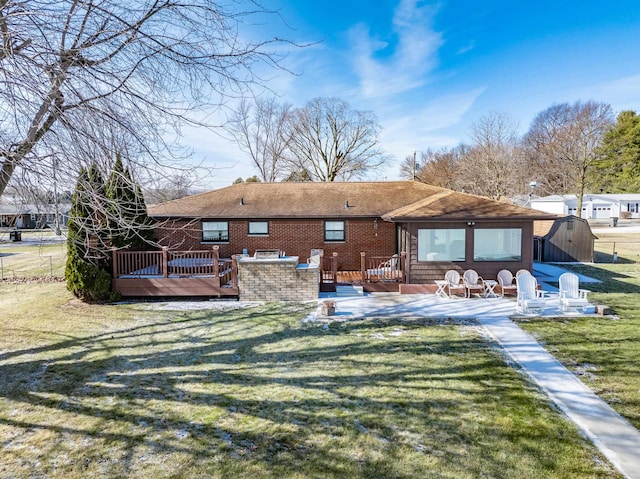 rear view of property with a patio, a yard, a deck, and a storage shed