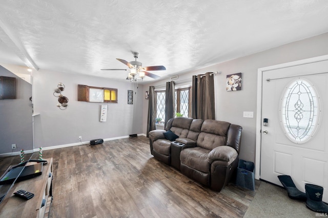 living room featuring wood-type flooring, ceiling fan, and a textured ceiling