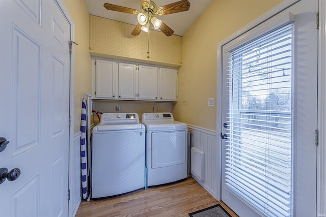 clothes washing area featuring cabinets, separate washer and dryer, ceiling fan, and light hardwood / wood-style flooring