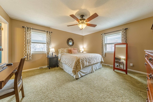 carpeted bedroom featuring multiple windows and a textured ceiling