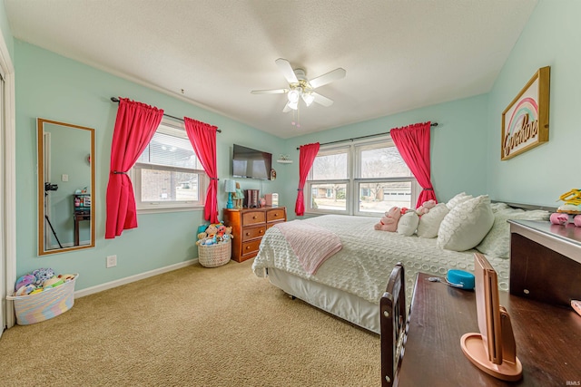 carpeted bedroom featuring ceiling fan, multiple windows, and a textured ceiling