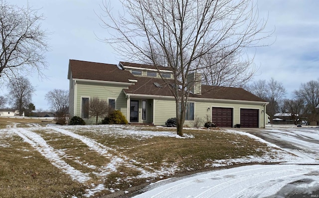 traditional-style house featuring a garage and driveway