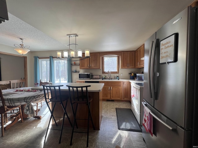 kitchen featuring pendant lighting, sink, stainless steel appliances, and a center island