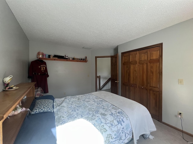 carpeted bedroom featuring a textured ceiling and a closet