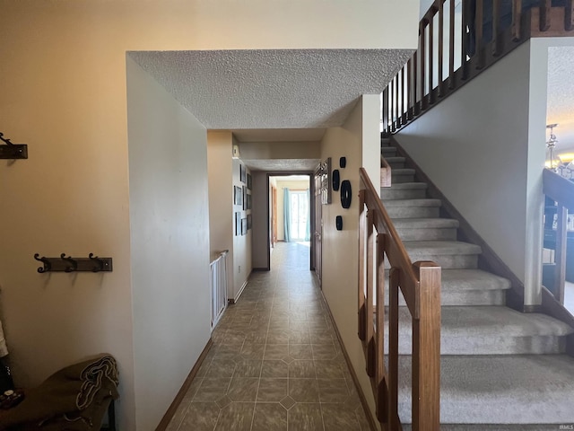 stairway featuring a textured ceiling