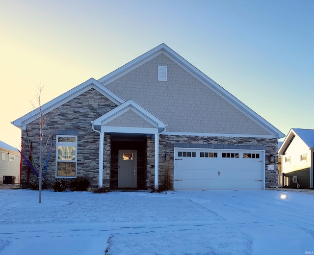 view of front of property featuring a garage and central air condition unit