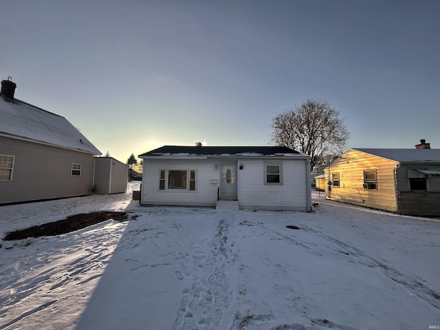 snow covered rear of property featuring entry steps