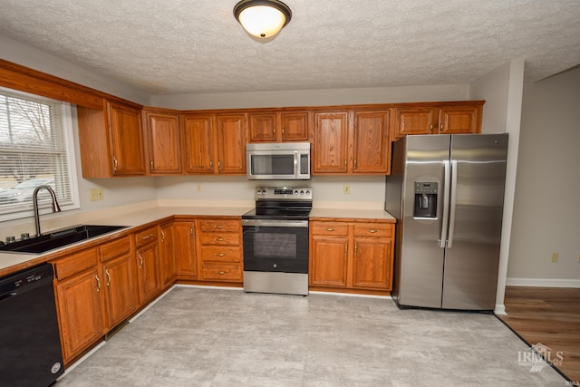 kitchen with stainless steel appliances, sink, and a textured ceiling