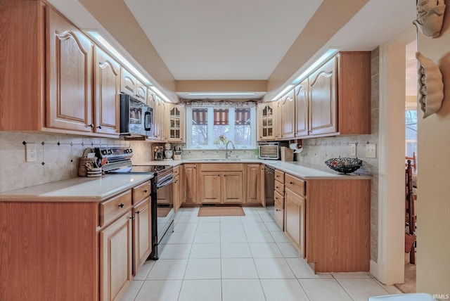 kitchen with sink, decorative backsplash, black appliances, and light tile patterned flooring