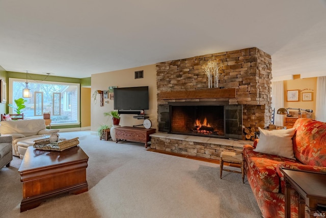 living room with a stone fireplace and carpet