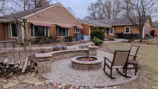 rear view of property featuring a patio area and a fire pit