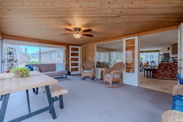 living room with ceiling fan, carpet floors, a wealth of natural light, and wood ceiling