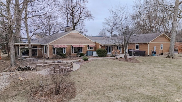 rear view of property with cooling unit, a yard, a jacuzzi, and a patio