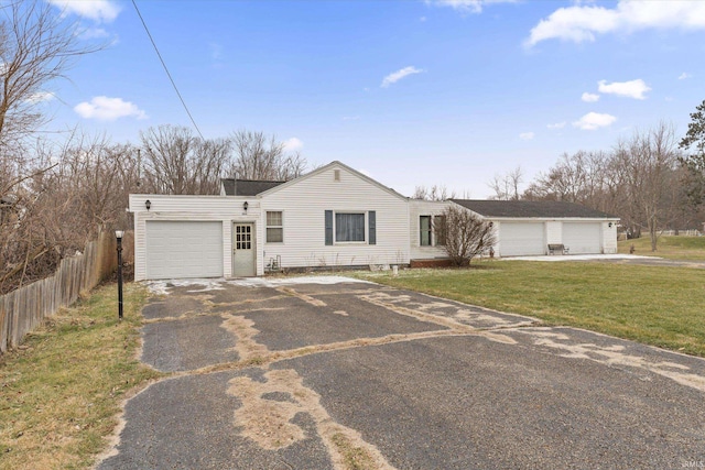 ranch-style home featuring a garage and a front lawn