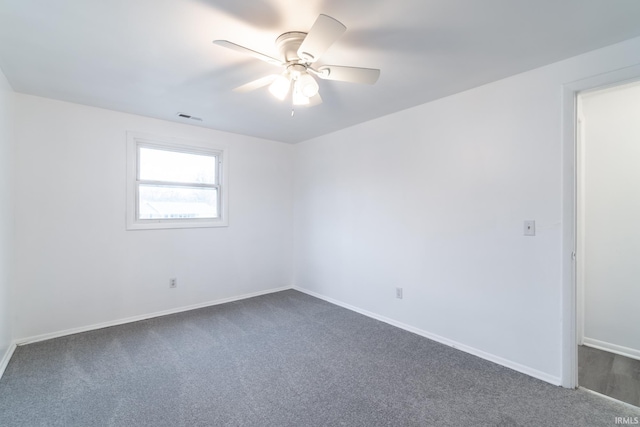 unfurnished room featuring dark colored carpet and ceiling fan