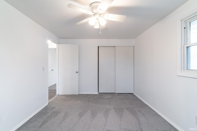 unfurnished bedroom with light carpet, a closet, and ceiling fan