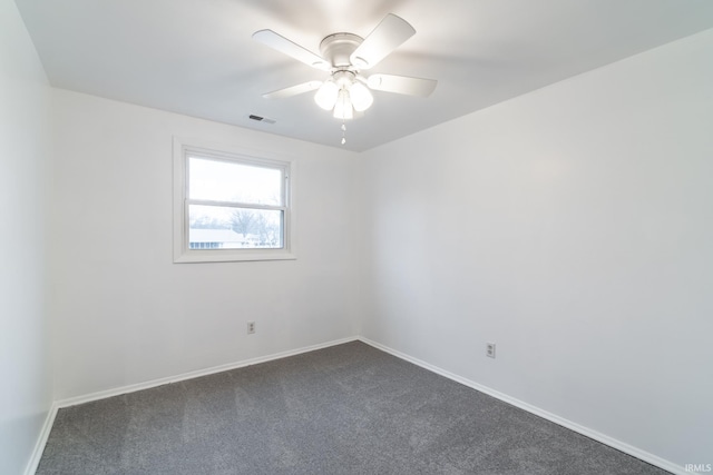 spare room featuring ceiling fan and dark carpet