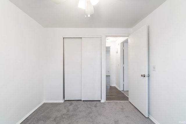 unfurnished bedroom featuring light carpet, ceiling fan, and a closet