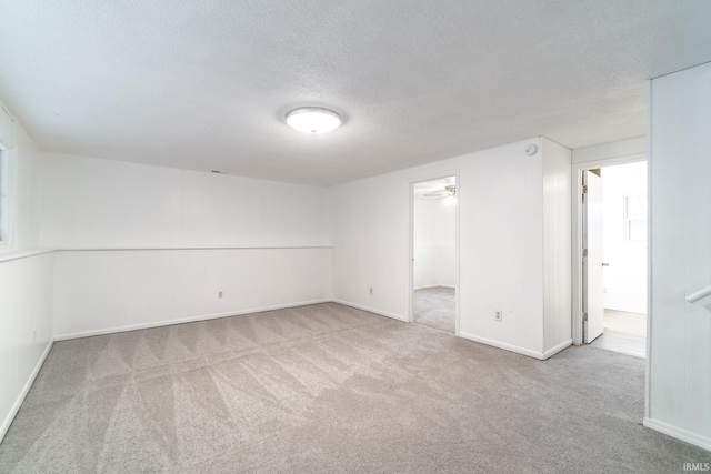 unfurnished room with light colored carpet and a textured ceiling