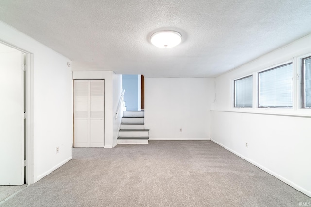 basement with light colored carpet and a textured ceiling